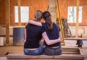 Picture of two girls sitting down happy about their renovation project that they funded from mortgage refinancing