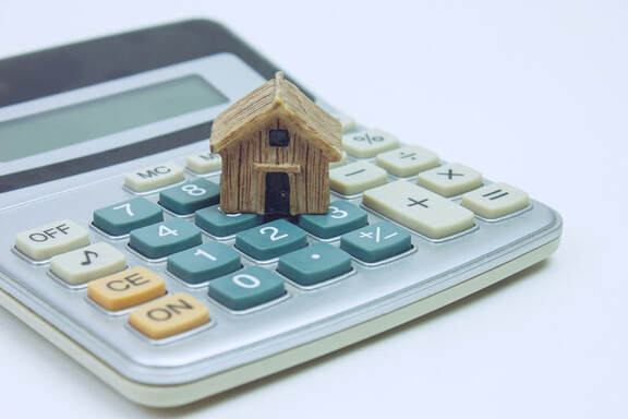 toy house sitting on top of a calculator representing a mortgage preapproval calculation