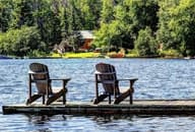 Picture of two lounge chairs on a dock on the lake of a vacation cottage property