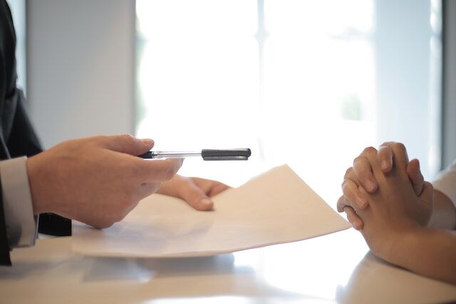 Image of two peoples hands renewing a mortgage contract with their mortgage broker